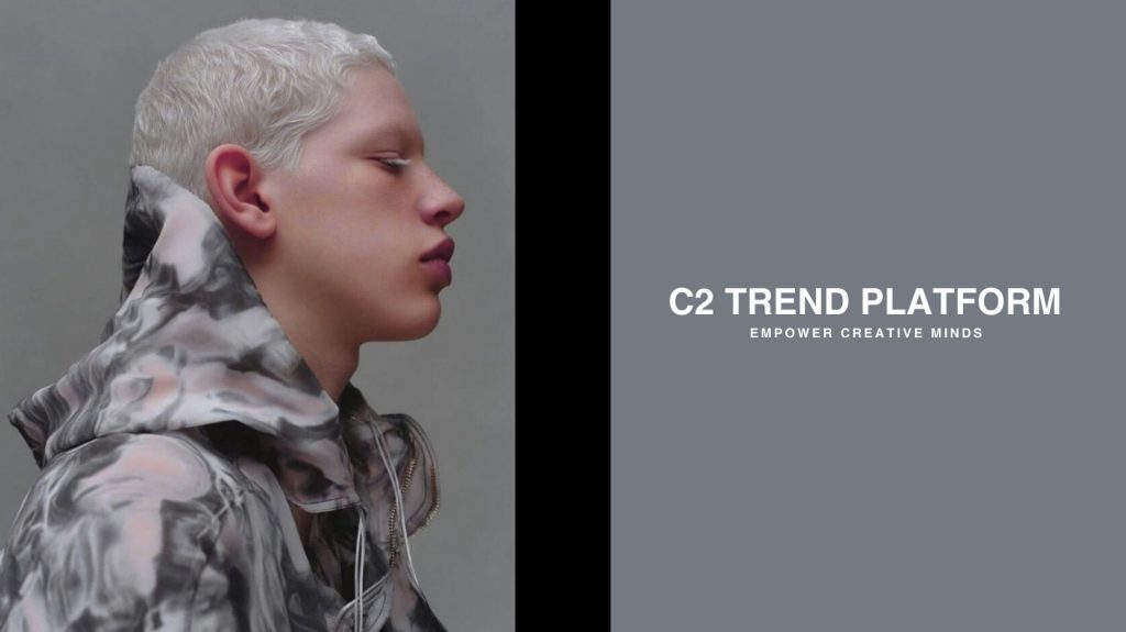 Side profile of a model wearing a marble-textured hooded garment with text reading ‘C2 Trend Platform – Empower Creative Minds,’ symbolizing future-focused sustainable fashion.