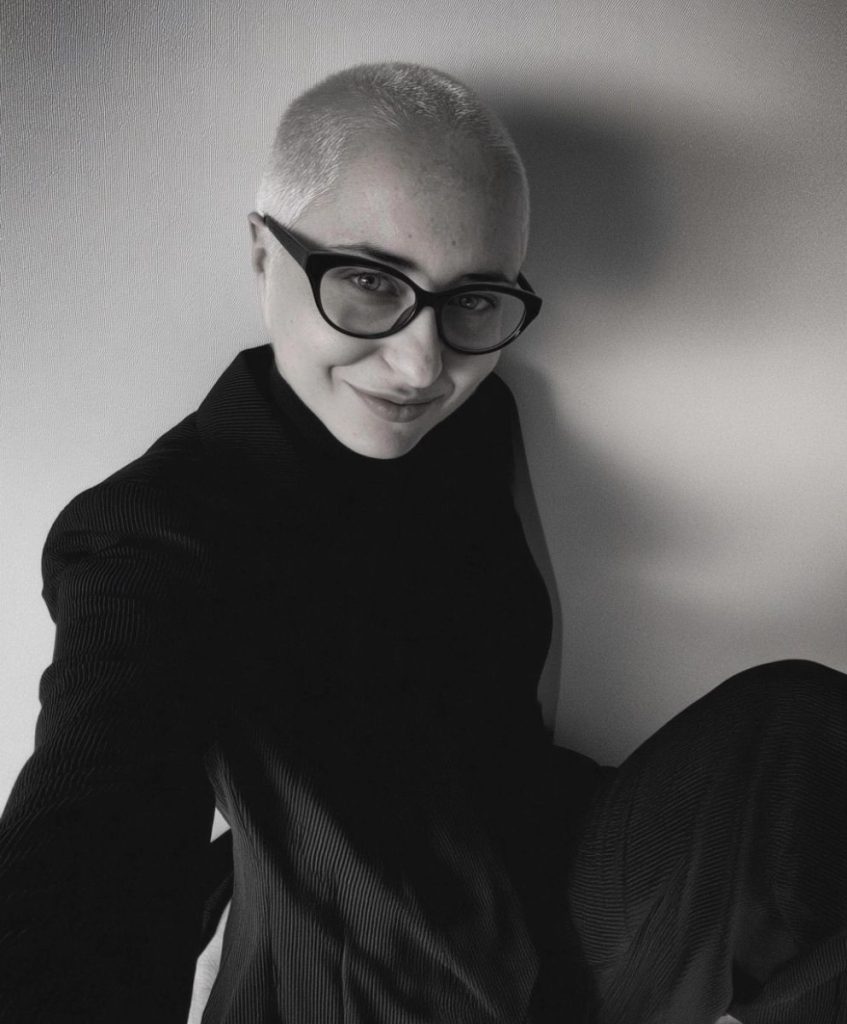Black and white portrait of Cristina Capucci, trend forecaster and founder of C2 Fashion Studio, wearing glasses and a textured black outfit.