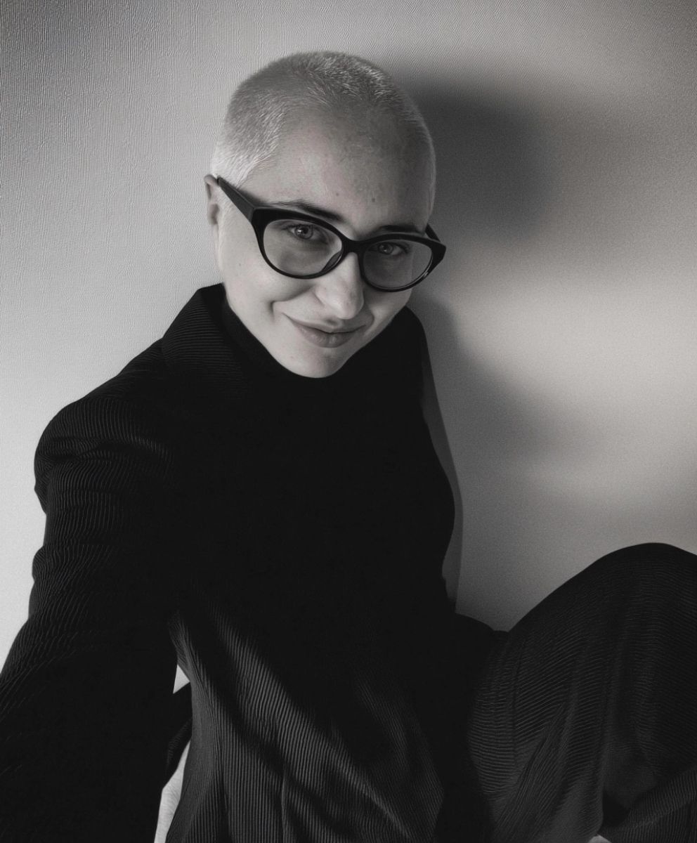 Black and white portrait of Cristina Capucci, trend forecaster and founder of C2 Fashion Studio, wearing glasses and a textured black outfit.