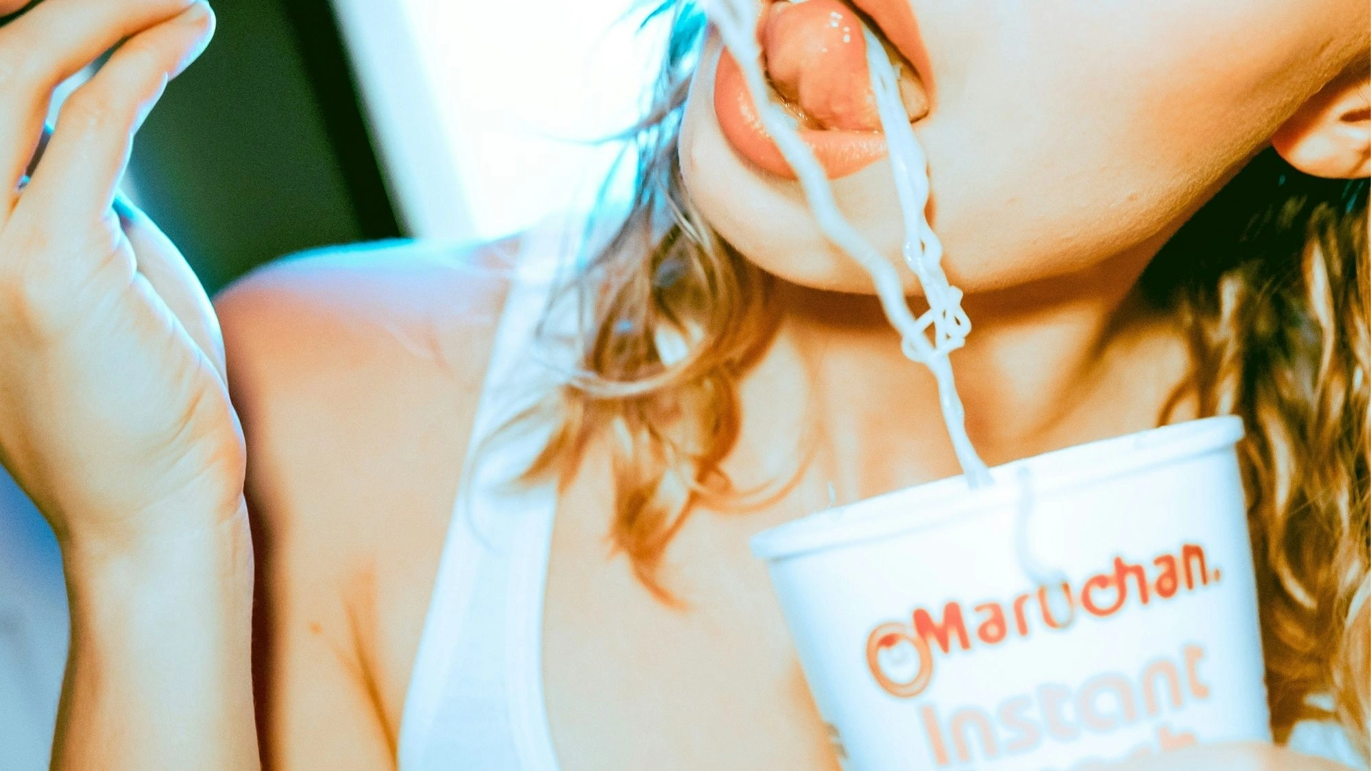 Close-up of woman eating instant noodles from a Maruchan cup — Gen Z lifestyle visual from a trend forecasting tool for influencers and creators.