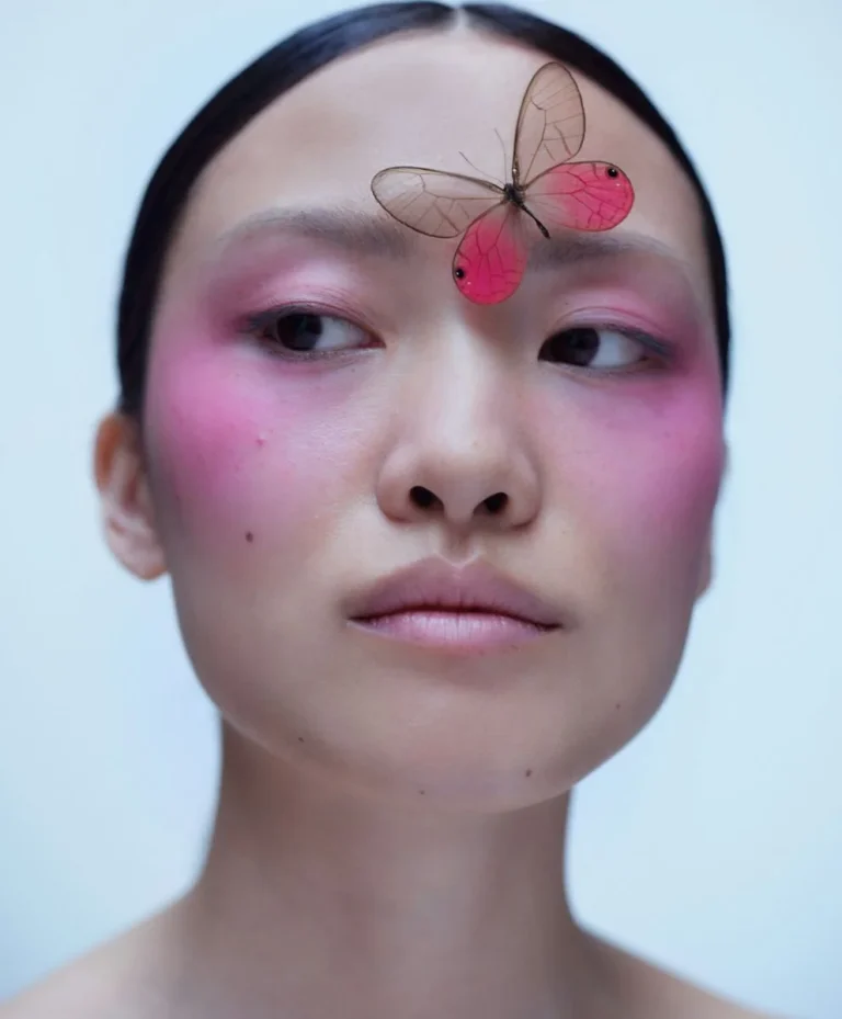 Model with pink blush and butterfly on forehead representing visionary beauty and customized trend forecasting