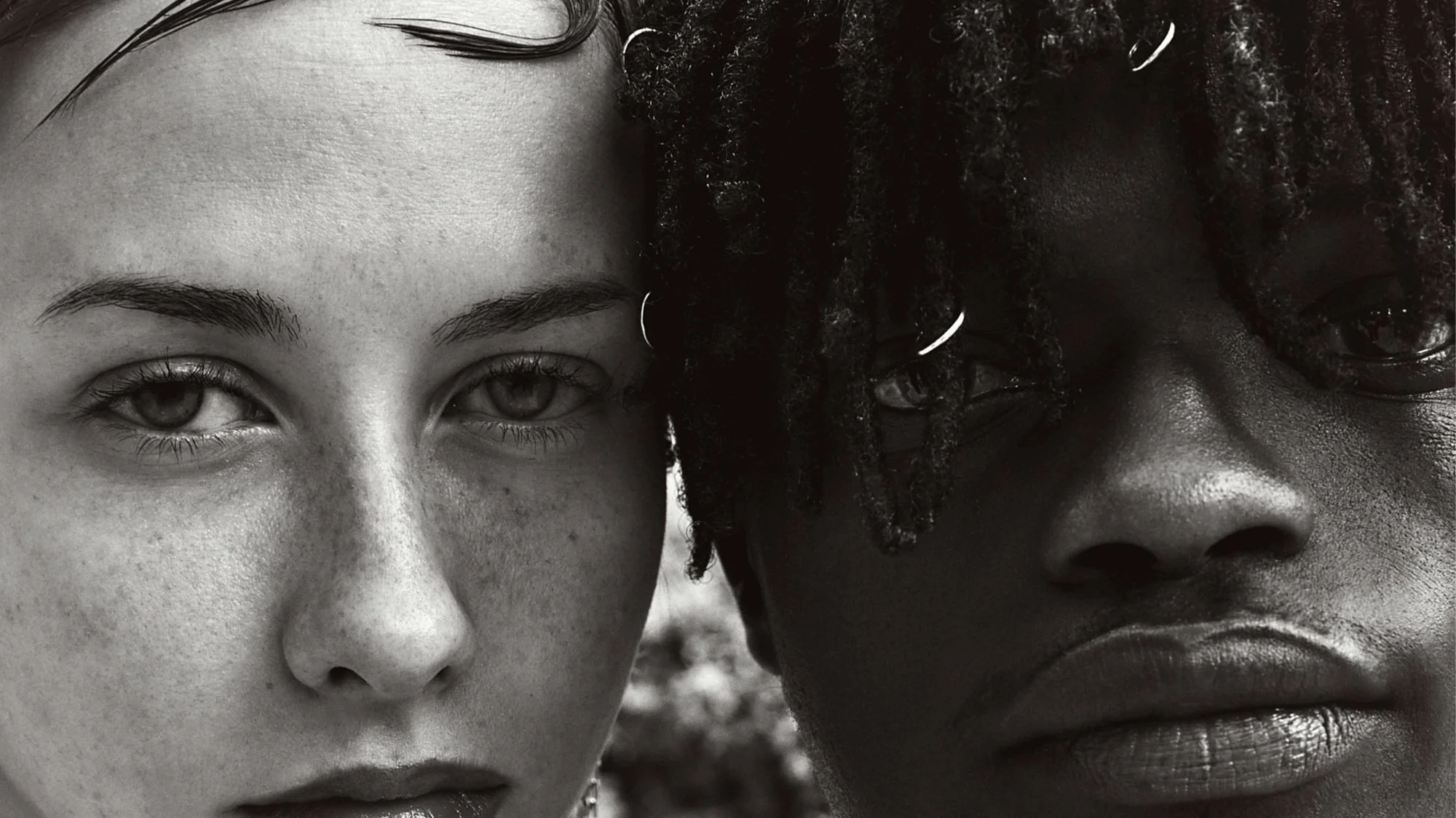 Black and white close-up portrait of two models side by side, reflecting fragmented styles, cultural shifts, and identity mashups in fashion. Curated by C2 Fashion Studio, a leading trend forecasting agency specializing in fashion trend forecasting.