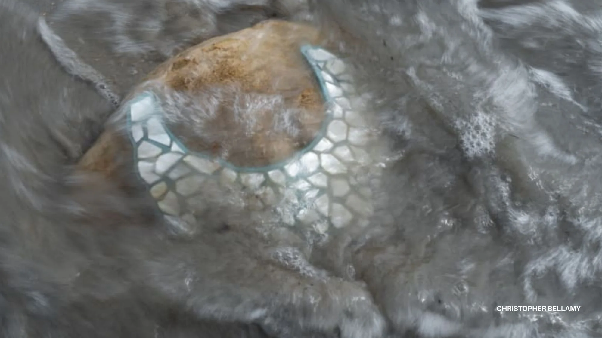 Close-up of a mosaic-textured necklace submerged in flowing water, symbolizing resilience, ecological imagination, and future fashion trends.