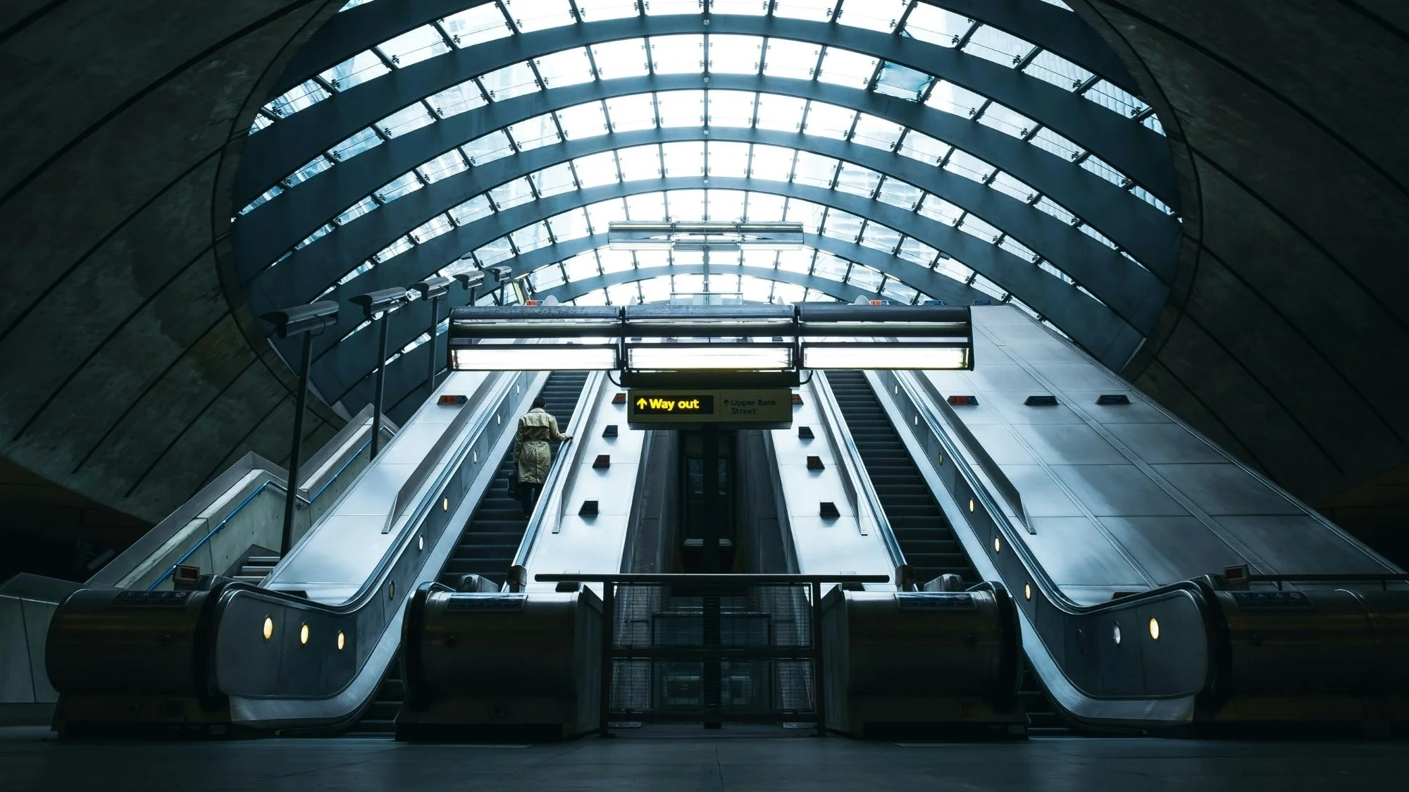 Futuristic escalator tunnel with architectural symmetry, reflecting themes of movement and transition used by C2 Fashion Studio, a trend forecasting agency, to illustrate emerging fashion trends.