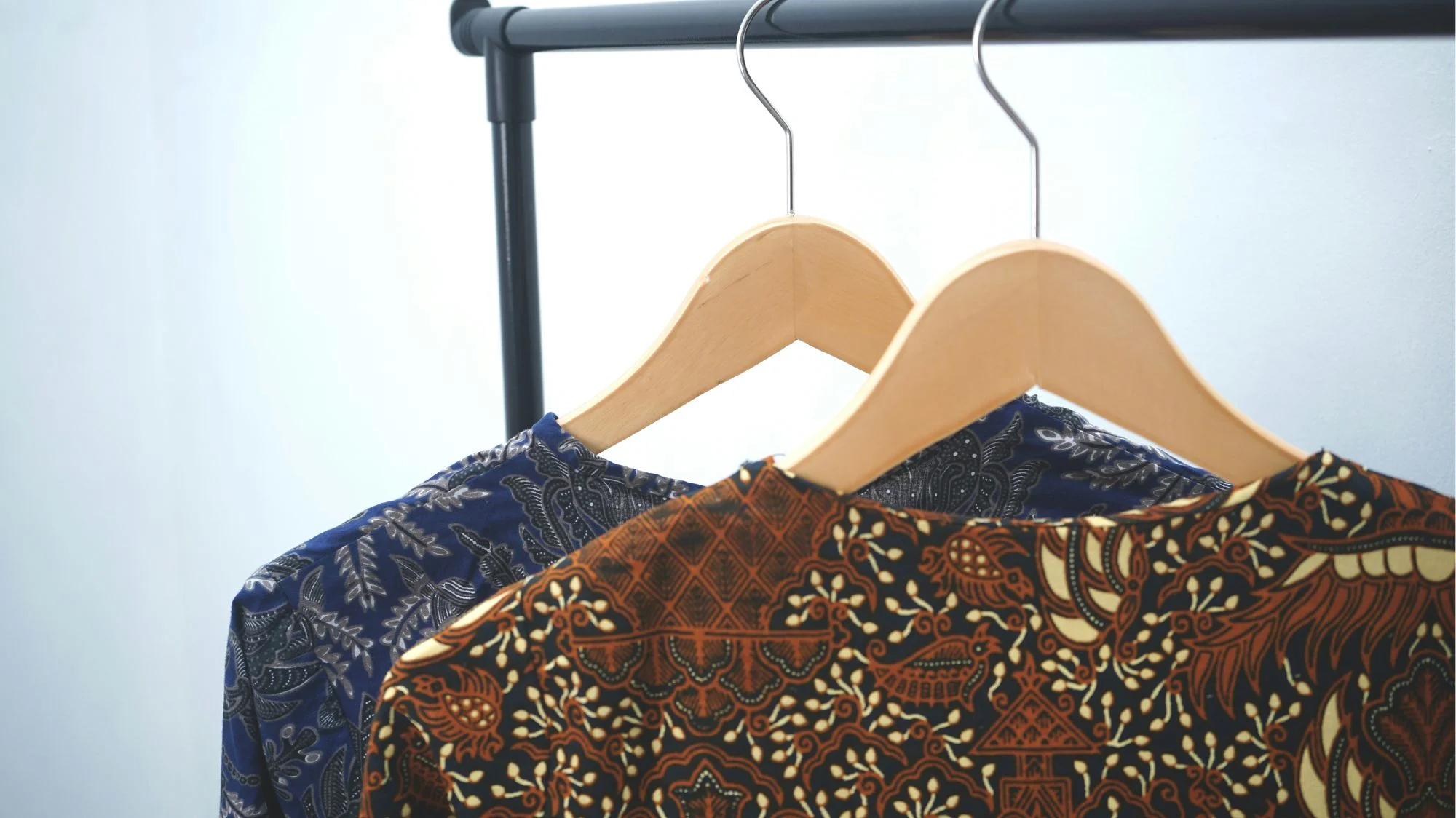 Two patterned garments on hangers, symbolizing the shift from fast fashion to durable, story-rich clothing. Concept by C2 Fashion Studio, a leading trend forecasting agency.