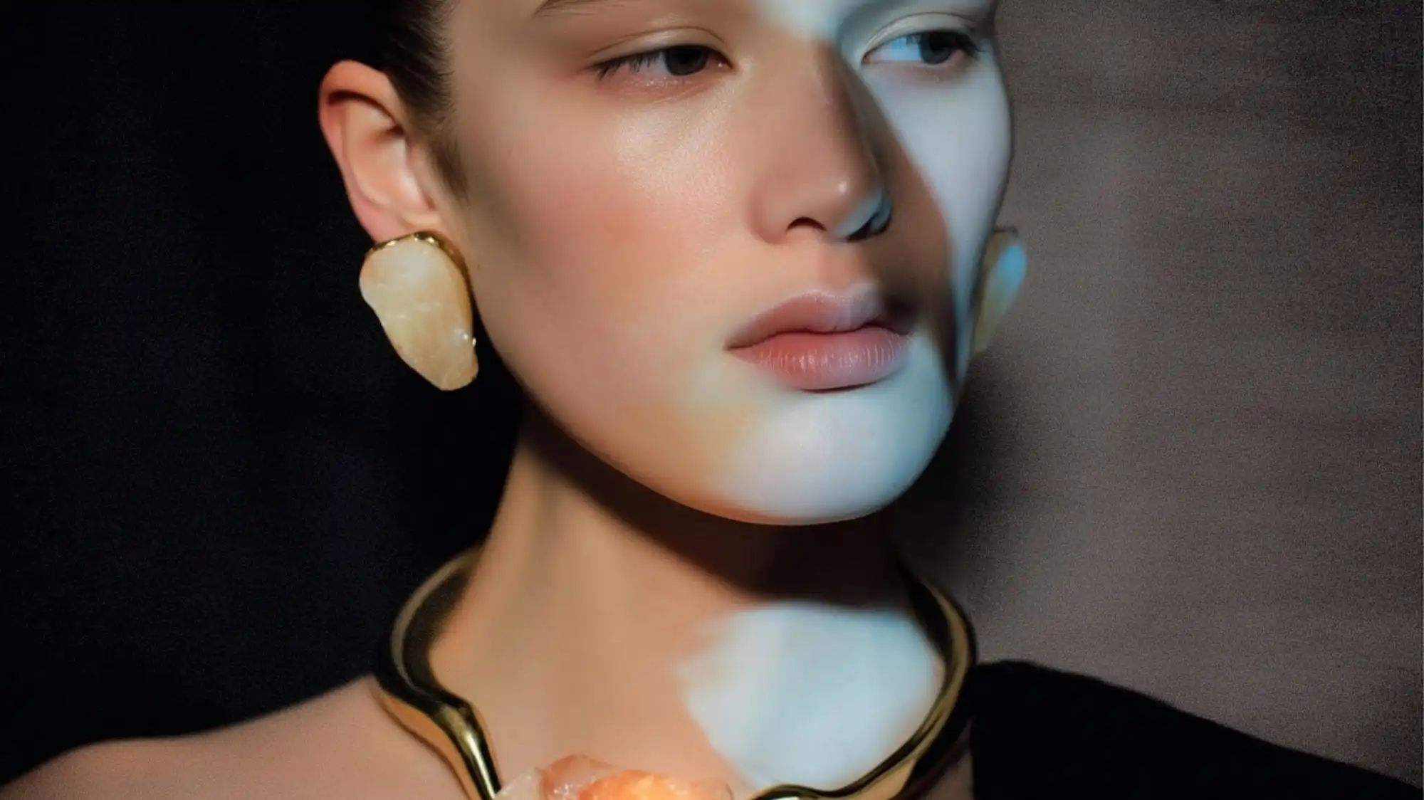 Close-up portrait featuring sculptural gold jewelry with translucent crystal stones, illustrating the Next-Gen Radiance jewelery trend from C2 Trend Platform’s Spring Summer 2027 Jewelery Trend Forecasts.