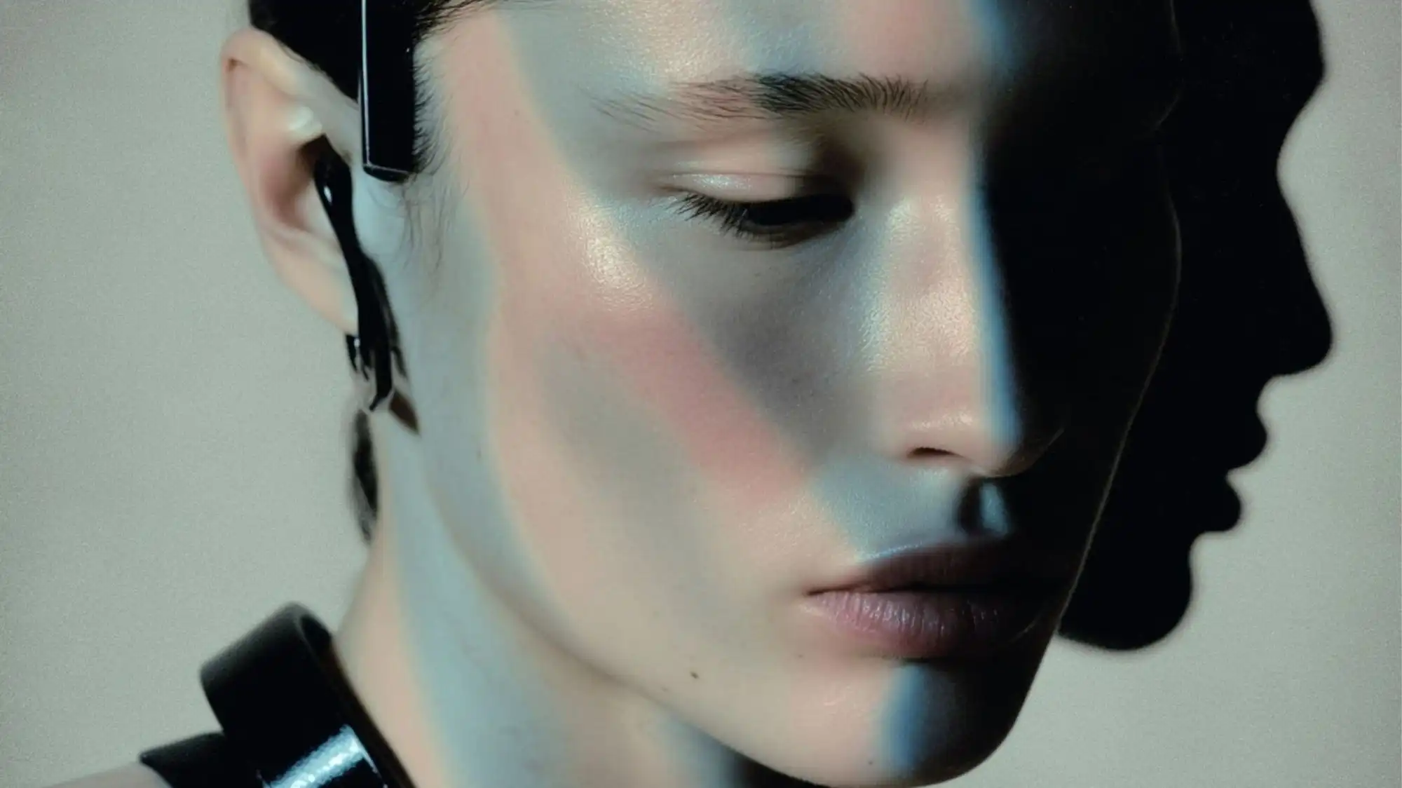 Close-up portrait of a futuristic model bathed in metallic light, symbolizing C2 Fashion Studio’s visionary approach to trend forecasting and the fusion of human emotion with technological aesthetics.