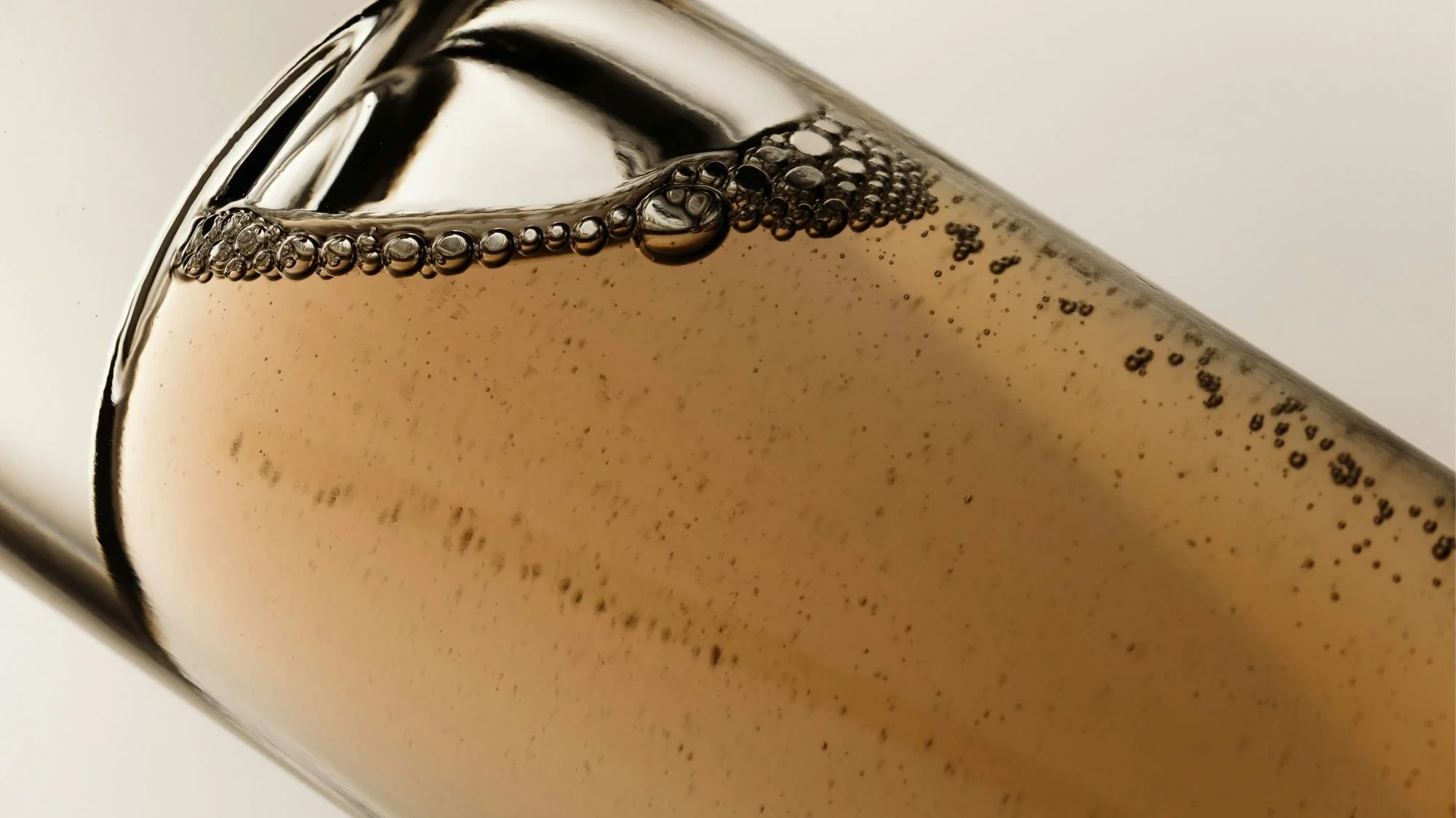 Close-up of golden liquid bubbles symbolizing the Carewear fashion trend, blending science, wellness, and emotional design — presented by C2 Fashion Studio.