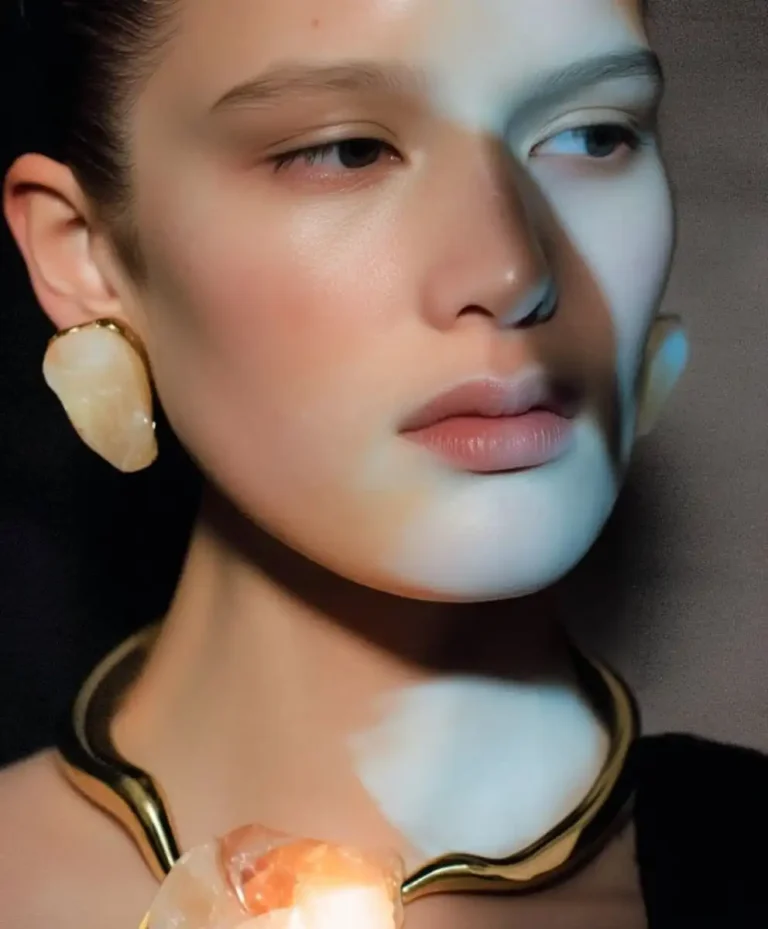 Close-up of a model wearing sculptural crystal jewelry in gold tones, representing the Next-Gen Radiance trend from C2 Trend Platform’s Jewelery Trend Forecasts for Spring Summer 2027.
