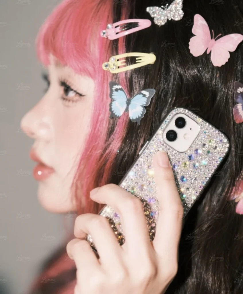 Close-up of a Gen Z individual with colorful butterfly hair clips and a glitter phone case, symbolizing self-expression, personalization, and co-creation culture explored by C2 Fashion Studio’s trend forecasting platform.