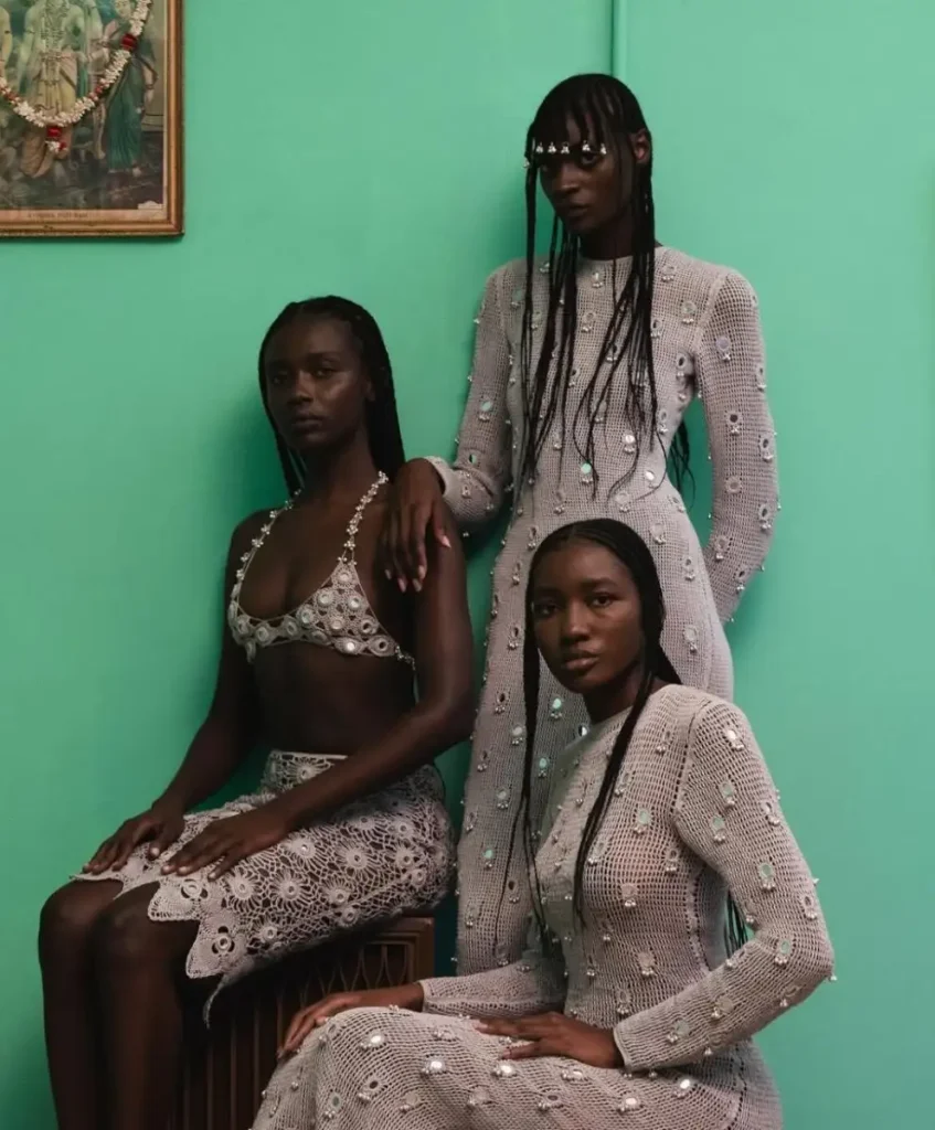 Three women wearing handcrafted crochet fashion adorned with pearls and textures — representing handmade craftsmanship, slow fashion, and ethical design in trend forecasting by C2 Fashion Studio.