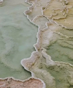 Aerial view of mineral formations in soft green and beige tones, inspiring Spring Summer 2028 color trend forecasting and C2’s Luminous Balance chromatic direction.