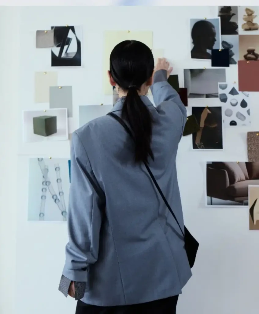 Fashion trend forecaster analyzing moodboard for Spring Summer 2027 at C2 Fashion Studio, exploring emotional intelligence in design.