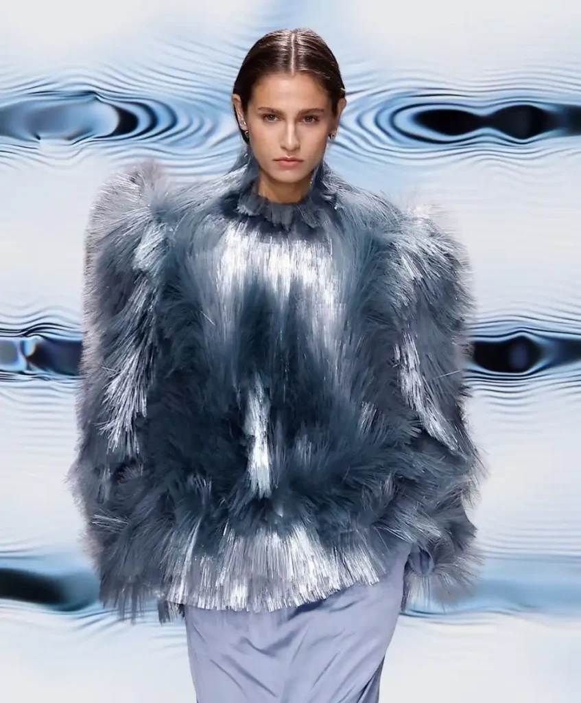 Model wearing metallic tactile-textured outfit in shades of blue and silver, representing Multisensory Experience — the C2 Fashion Studio trend forecast for Spring Summer 2027 focused on hyper-tactility and emotional design.