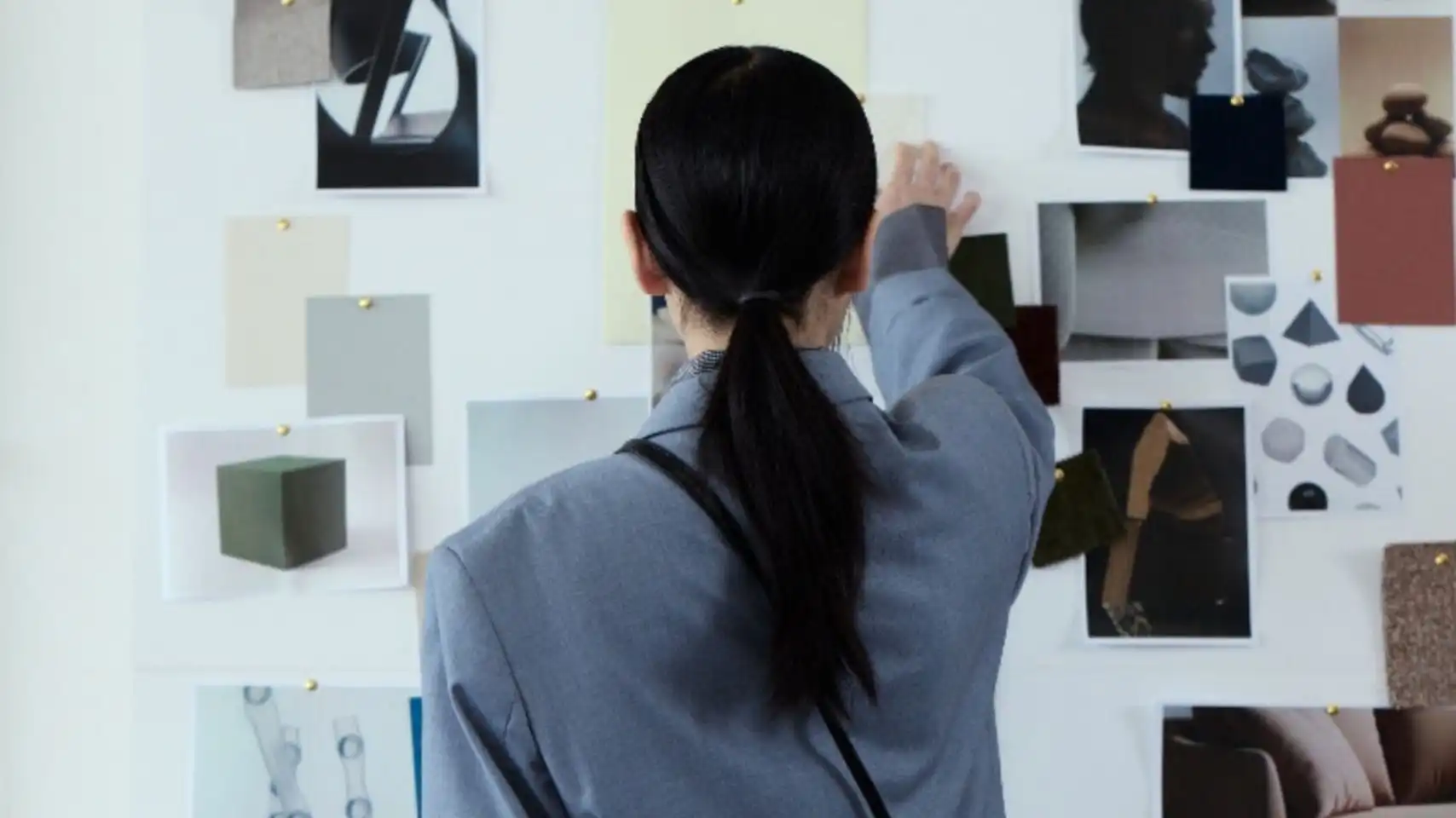 Fashion trend forecaster analyzing visual research and material references on a concept wall, representing advanced fashion trend forecasting inside the C2 Trend Platform.