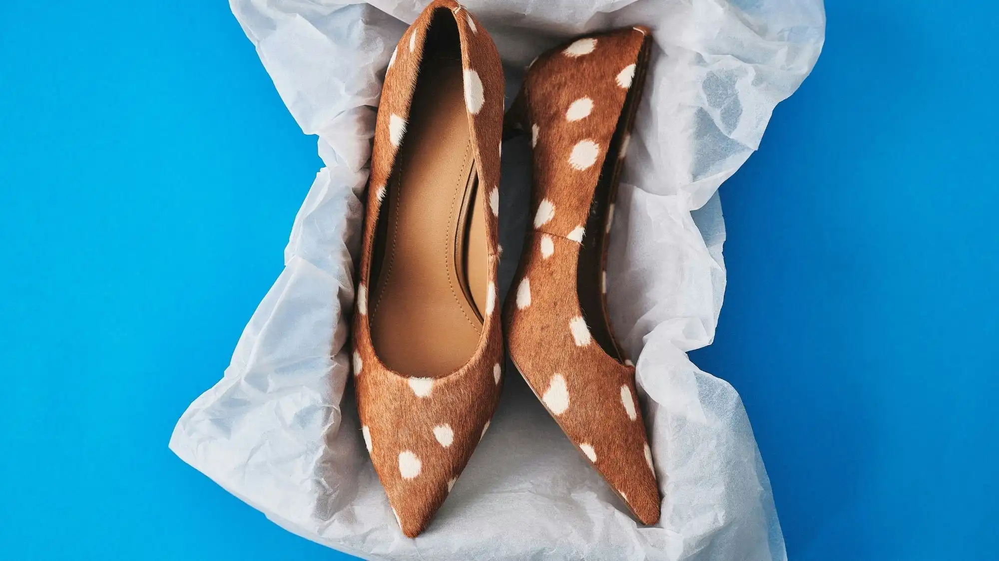 Vintage leather pumps with spotted pattern displayed in protective tissue paper, highlighting craftsmanship, material longevity, and value-driven resale and vintage fashion trends.