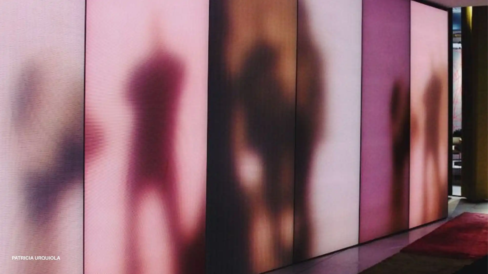 Soft-focus silhouettes behind illuminated gradient panels by Patricia Urquiola, illustrating Adaptive Belonging—one of the key macro forces in the Autumn Winter 2027–2028 Trend Forecast by C2 Fashion Studio.