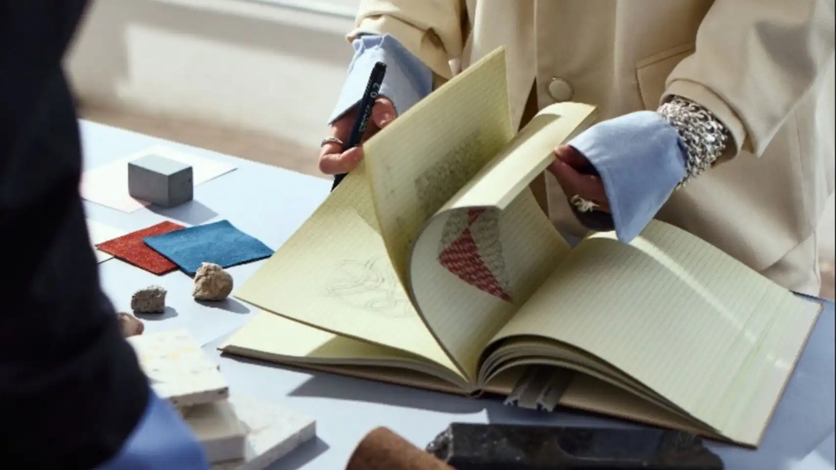 Fashion trend forecaster analyzing materials, sketches and samples during strategic research, illustrating advanced fashion trend forecasting inside the C2 Trend Platform.