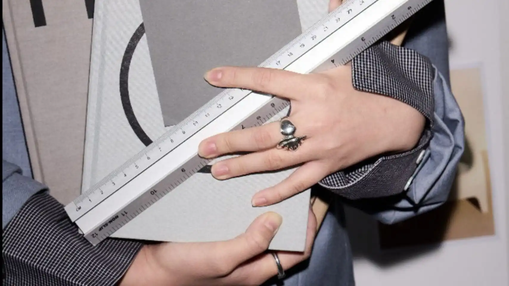 Fashion designer measuring material samples with ruler during research and development, illustrating strategic fashion trend forecasting inside the C2 Trend Platform.