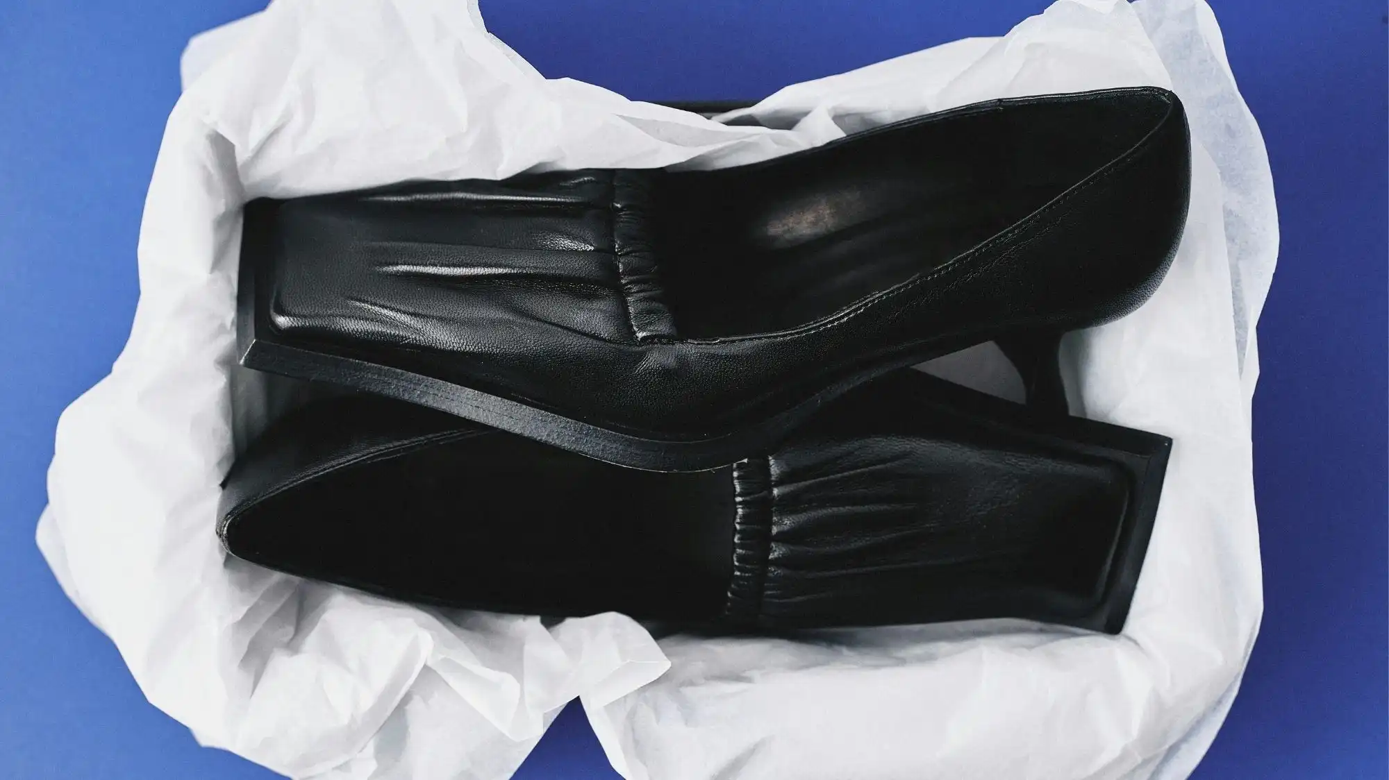 Vintage black leather pumps displayed in protective tissue paper, highlighting craftsmanship, material durability, and long-term value in resale and vintage fashion trends.