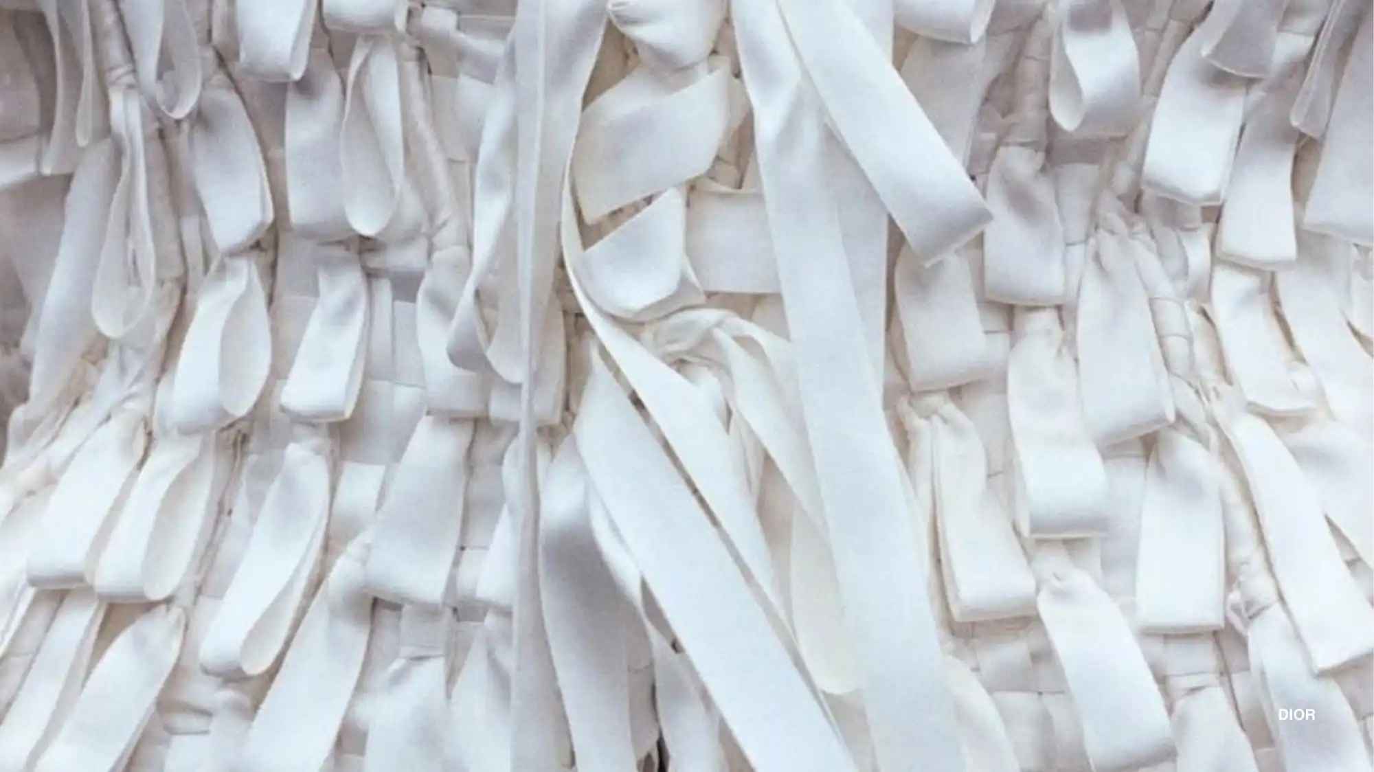 Dior Pre-Fall 2026/27 fabric detail with layered white ribbons and textured construction, highlighting material storytelling and strategic fashion trend forecasting.