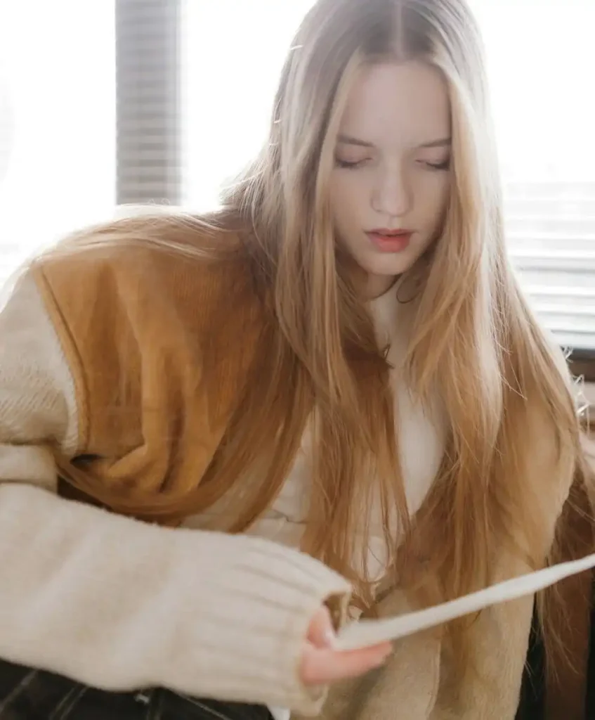 Young woman reading in soft natural light, reflecting the emotional clarity and calm aesthetic shaping the Future Consumer 2027 trend and the new emotional drivers redefining Trend Forecasting.