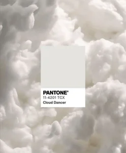 Pantone 11-4201 TCX Cloud Dancer swatch on a soft white cloud texture, representing the Pantone Color of the Year 2026 and its influence on future Color Trends and refined clarity in design.