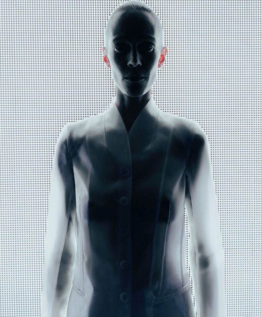 Futuristic abstract figure with fluid, light-responsive textures illustrating Material Luxury Intelligence and responsive materials for AW27/28 fashion trend forecasting.