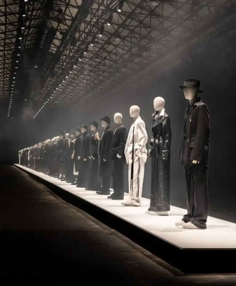 A dramatic runway installation featuring minimalist black-and-white silhouettes at a global fashion industry event, highlighting emerging AW27/28 trend directions.