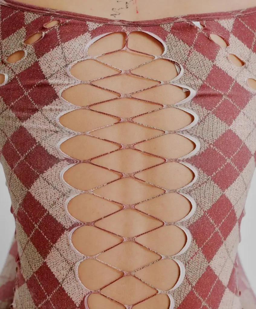 Close-up of vintage knitwear with laddered cut-out detailing, highlighting craftsmanship, material longevity, and value-driven fashion trends shaping the resale and vintage market.