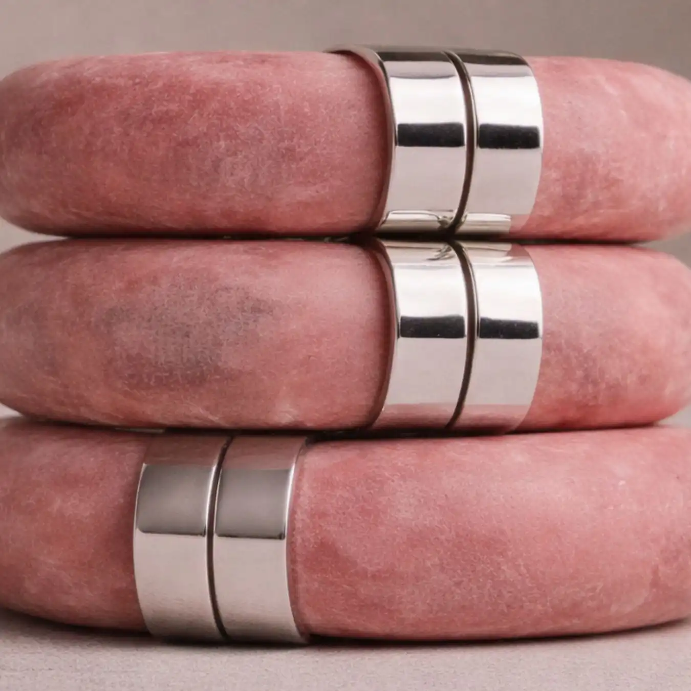 Close-up of stacked pink suede and polished silver rings, creating a soft yet precise material detail for Spring Summer 2028 fashion trend forecasting.