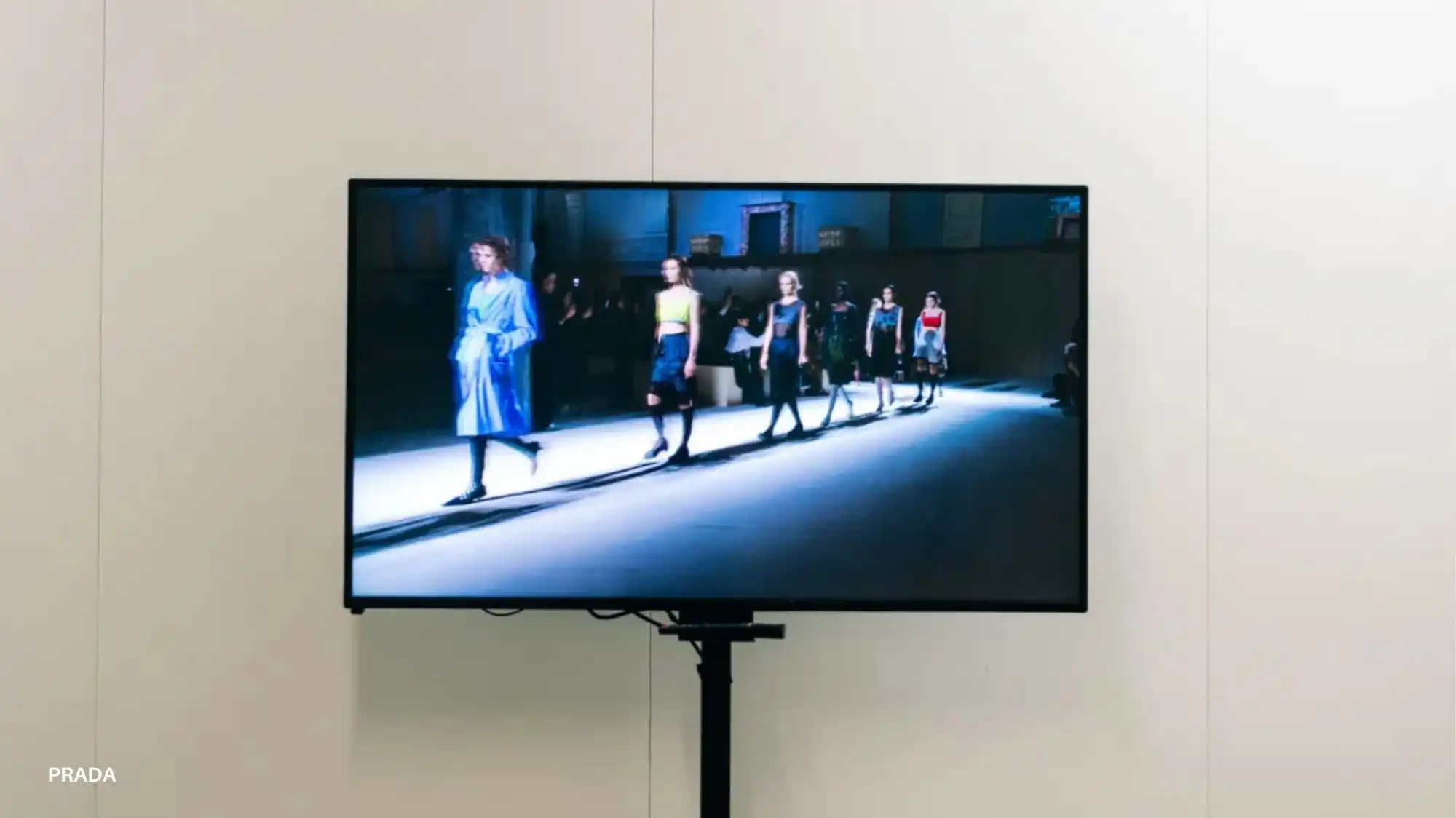 Prada Fall Winter 2026/27 runway video displayed on a screen highlighting layered silhouettes analyzed through Fashion Trend Forecasting and Trend Intelligence by C2 Fashion Studio Trend Forecasting.