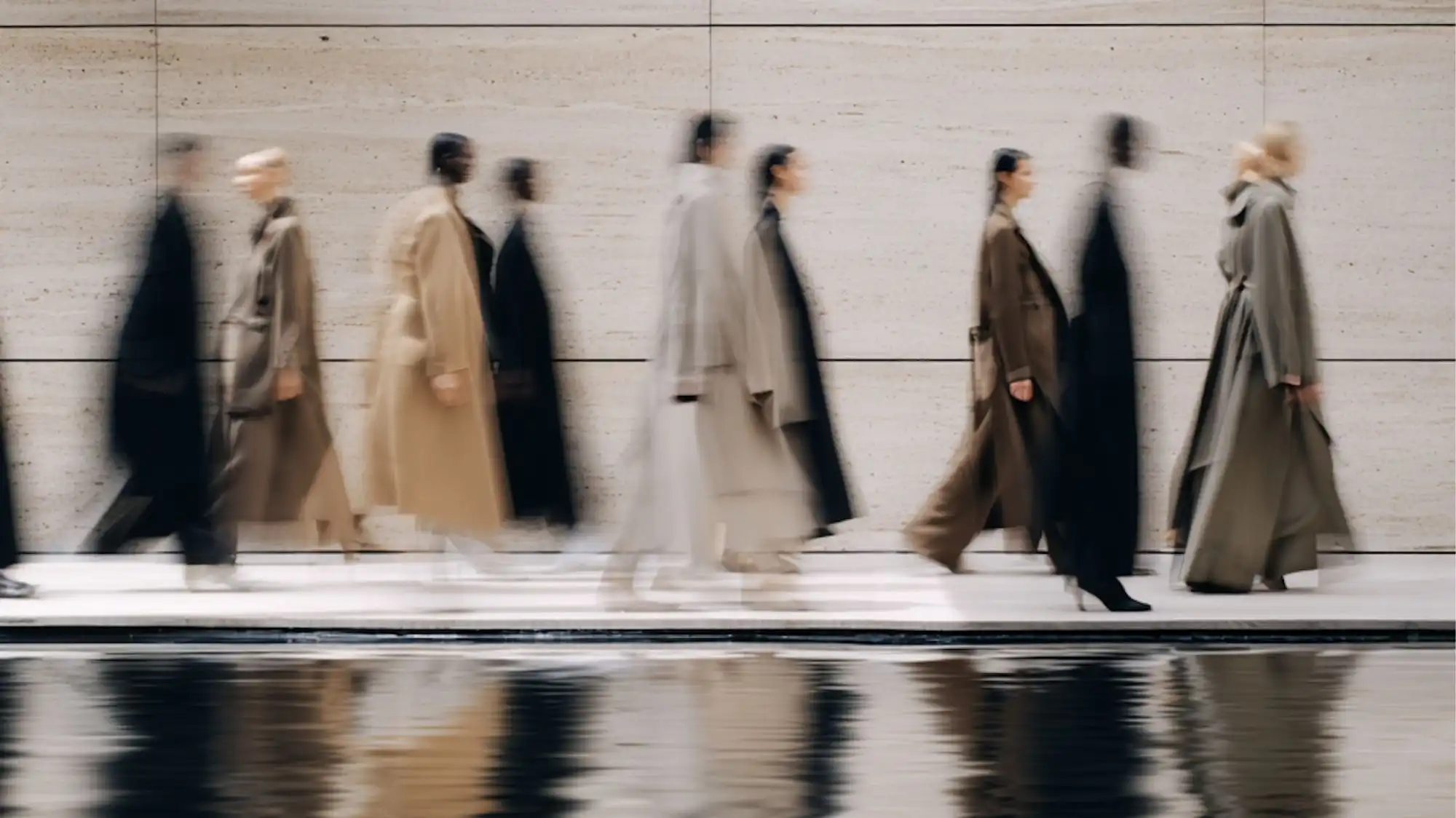 Minimal luxury fashion silhouettes in motion featuring fluid tailoring, neutral layered garments, and blurred movement aesthetics representing strategic fashion clarity and future consumer behavior for Autumn Winter 2027 2028.