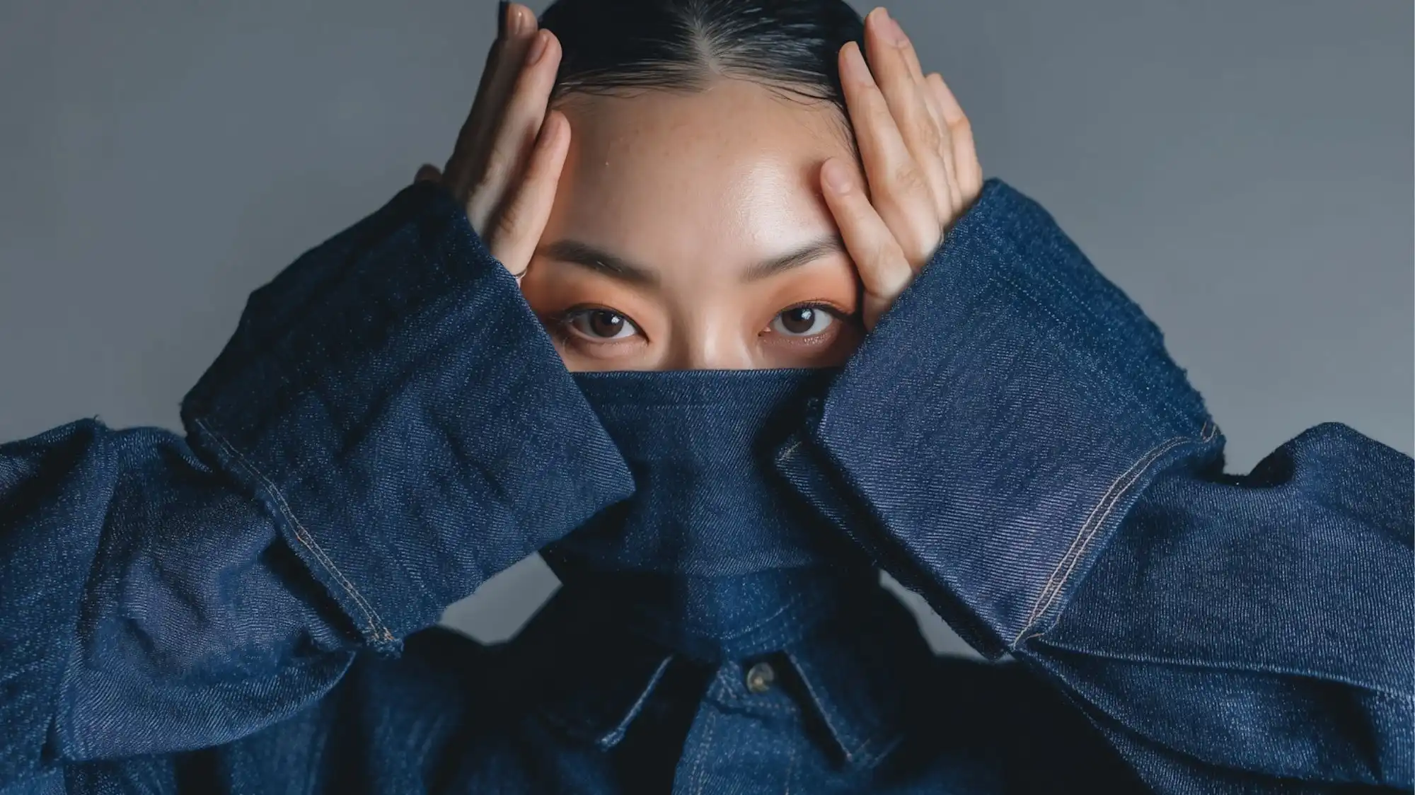 Circularity 2026 fashion trend forecasting concept featuring a model in dark indigo denim with oversized sleeves and protective styling, representing durability, material longevity, circular design strategies, repairability, and sustainable fashion innovation.